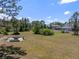 Spacious backyard featuring an outdoor firepit with seating, mature trees, and a glimpse of the main house at 21616 67Th E Ave, Bradenton, FL 34211