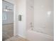A bathroom includes a bathtub and shower; a doorway leads to a bedroom at 21616 67Th E Ave, Bradenton, FL 34211