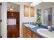 A bathroom features double sinks, a plant and doorway leading to bedroom with bookshelves at 21616 67Th E Ave, Bradenton, FL 34211