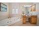 Bathroom featuring a large soaking tub, vanity with knee space and a window at 21616 67Th E Ave, Bradenton, FL 34211