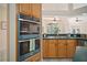 Well-lit kitchen with double ovens, wood cabinets, and views to the backyard at 21616 67Th E Ave, Bradenton, FL 34211