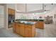 Open-concept kitchen features tile floors, an island cooktop, and access to the living room and backyard views at 21616 67Th E Ave, Bradenton, FL 34211