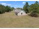 Outdoor storage outbuilding on a spacious lot, surrounded by a lush green lawn and mature trees at 21616 67Th E Ave, Bradenton, FL 34211