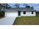 Charming single-story home featuring a two-car garage, well-maintained lawn, and neutral-toned exterior paint at 2163 Blaser St, Port Charlotte, FL 33980