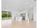 Bright open-concept living space with a modern white kitchen, stainless steel appliances, and sliding glass doors at 2163 Blaser St, Port Charlotte, FL 33980