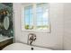 Bright bathroom offers a soaking tub and stylish vanity with a mosaic tile backsplash at 221 Grant Dr, Sarasota, FL 34236