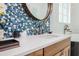 Elegant bathroom showcasing a round mirror and vanity with a colorful mosaic backsplash at 221 Grant Dr, Sarasota, FL 34236