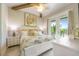Bedroom with a white bed frame, white dresser, decorative pillows, and access to an outdoor balcony at 221 Grant Dr, Sarasota, FL 34236