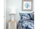 Bedroom view with bedside table, lamp, beach-themed art, and linens at 221 Grant Dr, Sarasota, FL 34236