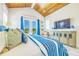 Bright bedroom with a blue striped comforter, wood ceiling, and sliding glass doors to a balcony at 221 Grant Dr, Sarasota, FL 34236