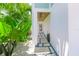 Inviting entryway leading to the front door with stone pavers and lush tropical plants at 221 Grant Dr, Sarasota, FL 34236