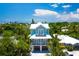 Stunning two-story coastal home featuring a double garage, and beautiful balconies overlooking the trees at 221 Grant Dr, Sarasota, FL 34236
