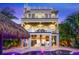 Stunning backyard oasis with pool, spa, covered patio, white rocking chairs, and lush tropical landscaping at 221 Grant Dr, Sarasota, FL 34236