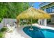 Inviting pool area featuring lush tropical landscaping and cozy seating for relaxation at 221 Grant Dr, Sarasota, FL 34236