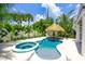 Backyard featuring a tiki-style pool, spa, and lush tropical landscaping at 221 Grant Dr, Sarasota, FL 34236