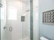 Glass walk-in shower with white subway tile and decorative blue accent tile at 221 Grant Dr, Sarasota, FL 34236
