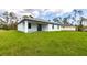 Expansive backyard featuring lush green grass and a covered patio, ideal for relaxation and entertaining at 2231 Hagoplan Ln, North Port, FL 34288