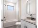 Modern bathroom featuring a shower-tub, white vanity, and sleek fixtures at 2231 Hagoplan Ln, North Port, FL 34288