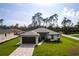 Charming home exterior featuring a paved driveway, dark accents, and lush landscaping, ideal for curb appeal at 2231 Hagoplan Ln, North Port, FL 34288