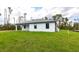 Home exterior view showcasing the well-manicured lawn with a modern architectural design under a bright sky at 2231 Hagoplan Ln, North Port, FL 34288