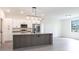 Open kitchen with stainless steel appliances, gray island, and tile flooring at 2231 Hagoplan Ln, North Port, FL 34288