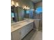 Modern bathroom with a double vanity, large mirror, and a glass-enclosed shower at 24835 Buckingham Way, Port Charlotte, FL 33980