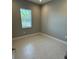 Neutral-toned bedroom with natural light and tile flooring, providing a serene and comfortable space at 24835 Buckingham Way, Port Charlotte, FL 33980