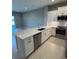 Elegant kitchen with stainless steel appliances and a large center island, flowing into an open living area at 24835 Buckingham Way, Port Charlotte, FL 33980