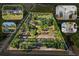 Expansive aerial view of property offered at auction featuring lush greenery, pond, house, outdoor living, and modern kitchen at 25305 83Rd E Ave, Myakka City, FL 34251