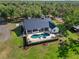 Aerial view highlighting a kidney-shaped pool, covered patio, and lush landscaping at 25305 83Rd E Ave, Myakka City, FL 34251