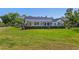 Backyard view of a modern farmhouse with a covered patio and landscaped garden beds at 25305 83Rd E Ave, Myakka City, FL 34251