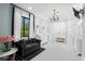 Spacious bathroom with tiled floors, a chandelier, a double shower, a black sofa, and black and white striped curtains at 25305 83Rd E Ave, Myakka City, FL 34251