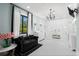 Spacious bathroom with tiled floors, a chandelier, a double shower, a black sofa, and black and white striped curtains at 25305 83Rd E Ave, Myakka City, FL 34251