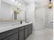 Modern bathroom featuring a large vanity with gray cabinetry and a spacious glass-enclosed shower at 25305 83Rd E Ave, Myakka City, FL 34251
