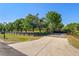 Concrete driveway leading to a gated entrance lined with mature trees at 25305 83Rd E Ave, Myakka City, FL 34251