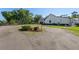 Long driveway leading to a modern farmhouse with a well-maintained yard and landscaping at 25305 83Rd E Ave, Myakka City, FL 34251