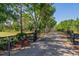 Gated entrance with black fencing, landscaping, and an asphalt driveway at 25305 83Rd E Ave, Myakka City, FL 34251