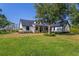Beautiful farmhouse style home with metal roof, lush lawn, and manicured landscaping at 25305 83Rd E Ave, Myakka City, FL 34251