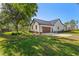 Exterior view of a modern farmhouse with a metal roof, lush landscaping, and a spacious driveway at 25305 83Rd E Ave, Myakka City, FL 34251