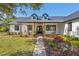 Charming home with a manicured lawn, metal roof, inviting porch, and meticulously landscaped front yard at 25305 83Rd E Ave, Myakka City, FL 34251