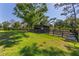 Spacious paddock featuring lush green grass, mature trees, and a wooden shelter at 25305 83Rd E Ave, Myakka City, FL 34251