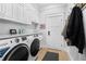 Well-lit laundry room with modern appliances, cabinets, and convenient coat hooks at 25305 83Rd E Ave, Myakka City, FL 34251