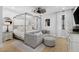 Bright main bedroom with a four-poster bed, neutral decor, and modern ceiling fan at 25305 83Rd E Ave, Myakka City, FL 34251