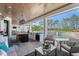 Covered outdoor kitchen and living area with a view of the swimming pool and lush landscaping at 25305 83Rd E Ave, Myakka City, FL 34251