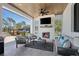Outdoor living area with fireplace, ceiling fan, comfortable seating, and backyard views at 25305 83Rd E Ave, Myakka City, FL 34251