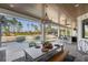 Elegant covered patio with a chandelier, a large dining table, an outdoor kitchen, and a stunning view of the pool at 25305 83Rd E Ave, Myakka City, FL 34251