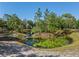 Lush pond featuring lily pads and an island, set within a serene landscape with trees at 25305 83Rd E Ave, Myakka City, FL 34251