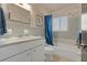 Bathroom with a vanity, mirror, tub with shower, blue shower curtain, and tiled walls at 2708 Fort Worth St, Sarasota, FL 34231