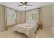 Sun-filled bedroom with neutral tones, featuring two windows, bench, and ceiling fan at 2708 Fort Worth St, Sarasota, FL 34231