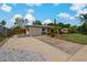 Home featuring a spacious driveway, well-kept lawn, landscaping, and a carport at 2708 Fort Worth St, Sarasota, FL 34231